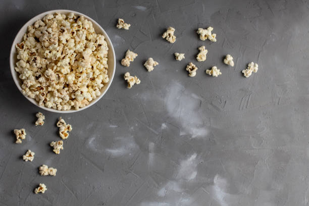 istock Popcorn in white bowl on grey table. Top view with copyspace 1272931851