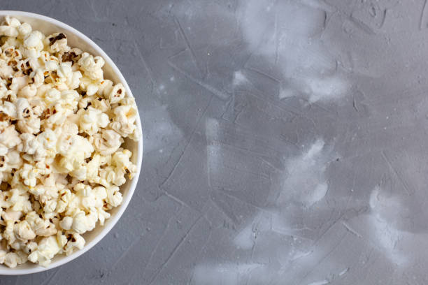 istock Popcorn in white bowl on grey table. Top view with copyspace 1272931856