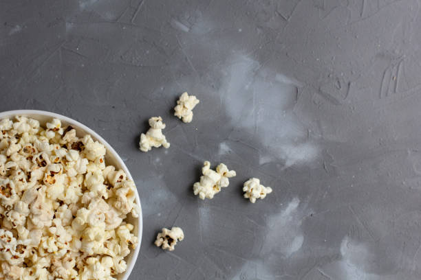 istock Popcorn in white bowl on grey table. Top view with copyspace 1272931869