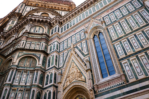 Florence, Italy -- A detailed view of the left side of the Cathedral of Santa Maria del Fiore, also known as the Duomo of Florence, and his baptistery. The Duomo is the third Cathedral in Europe, after St. Peter's in Rome and St. Paul's in London. The construction work began in 1296, while the consecration of the temple took place in 1436. Image in High Definition format.