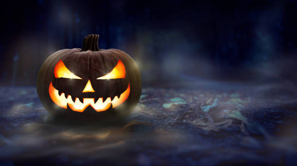 istock One spooky halloween pumpkin, Jack O Lantern, with evil face and glowing eyes. 1272936859