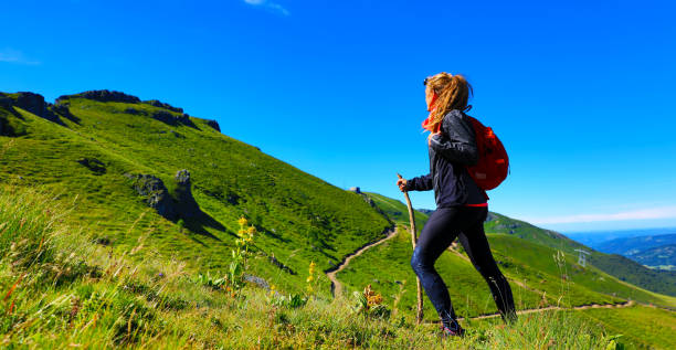 hiking trail, woman with backpack- Lead of Cantal, Auvergne-Cantal hiking trail, woman with backpack- Plomb du Cantal, Auvergne-Cantal auvergne rhône alpes stock pictures, royalty-free photos & images