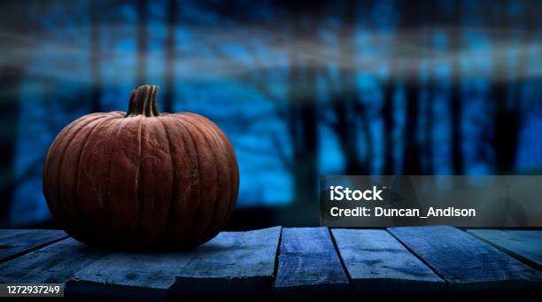 One Spooky Halloween Pumpkin Blank Template On A Wooden Bench With A Misty Forest Night Background Stock Photo - Download Image Now