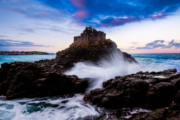 istock Strong wave crashing rocks along the coast line in Australia 1272937678