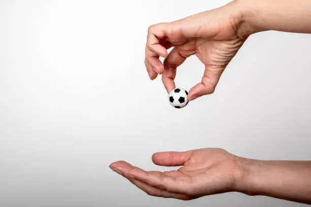 Photo of Miniature soccer ball in woman's hand. Popular sport, entertainment, business and lifestyle concept