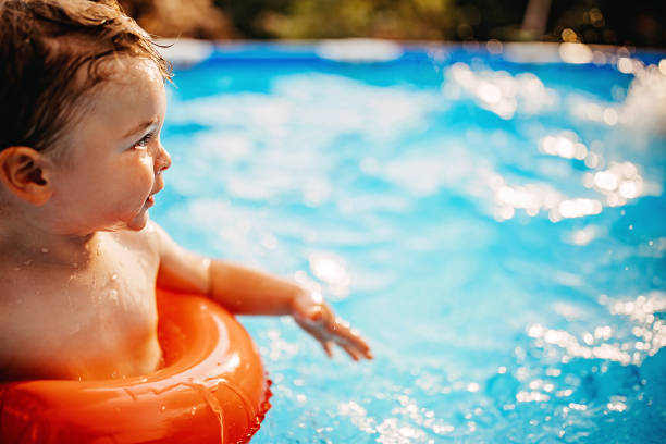 istock Boy playing in water with inflatable ring 1272944466