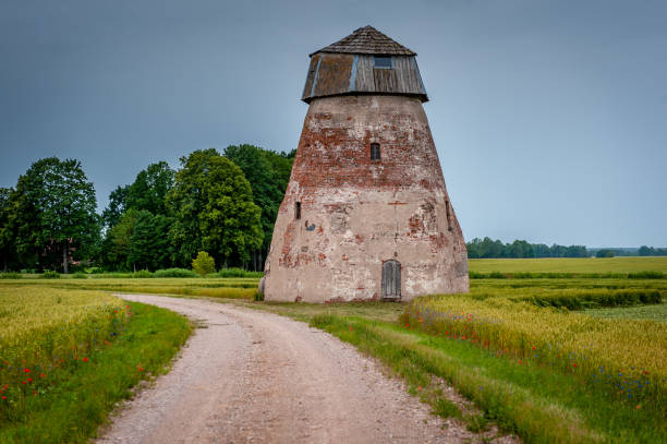 istock Rural road leading through the fields to the abandoned windmill. 1272947680