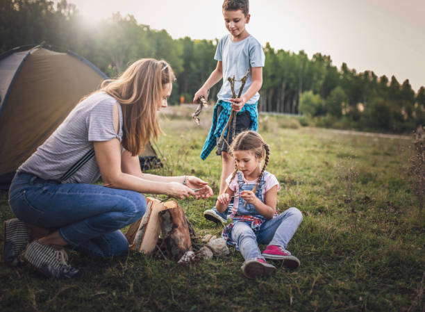 istock Mother and  children roasting marshmallows in campfire 1272949274