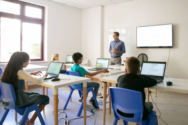 istock Confident teacher explaining lesson to pupils 1272949318
