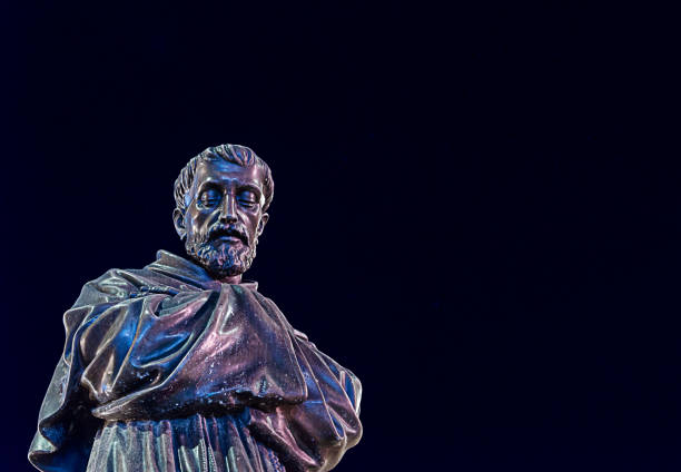 CAGLIARI, SARDINIA, ITALY - August 12 2020: Bronze statue of St. Francis of Assisi with night sky background