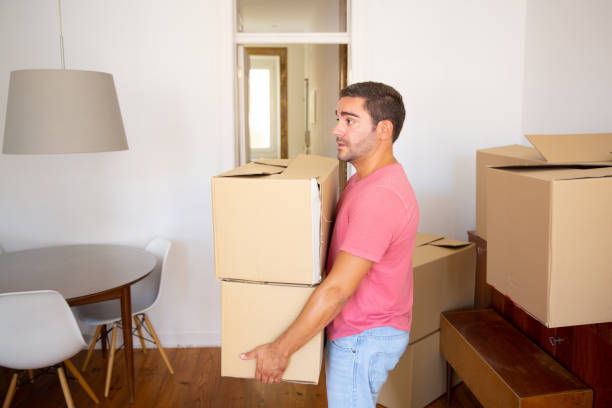 istock Focused man carrying carton boxes into new apartment 1272954009