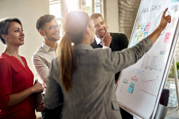 istock Team of entrepreneurs cooperating while working on new ideas on whiteboard in the office. 1272954932
