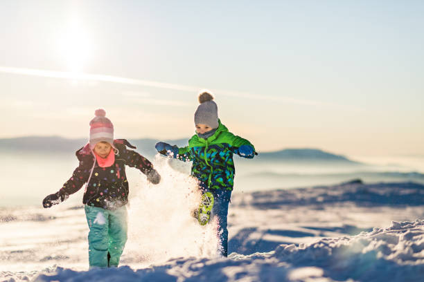 istock Happy kids enjoying winter snow 1272955393