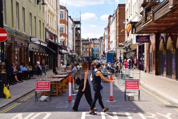 コービッド-19サインを持つオールドコンプトンストリート、ソーホー、ロンドンのバーの人々 - urban scene regent street city of westminster inner london ストックフォトと画像