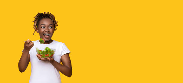 istock Cheerful african woman with salad looking at copy space 1272958320