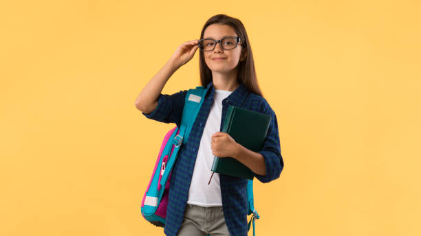 uśmiechnięta dziewczyna trzymająca podręcznik na tle studia - male education college student nerd zdjęcia i obrazy z banku zdjęć