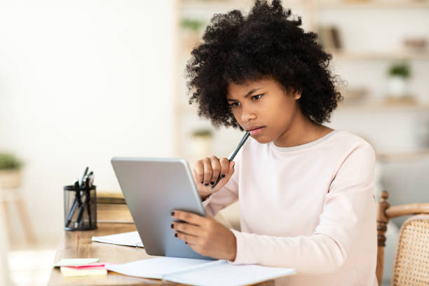 istock Teen Girl Using Tablet Thinking On Task Sitting At Home 1272960127