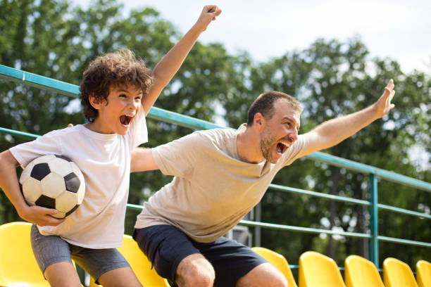 istock Men watching football game on stadium and cheering 1272960189