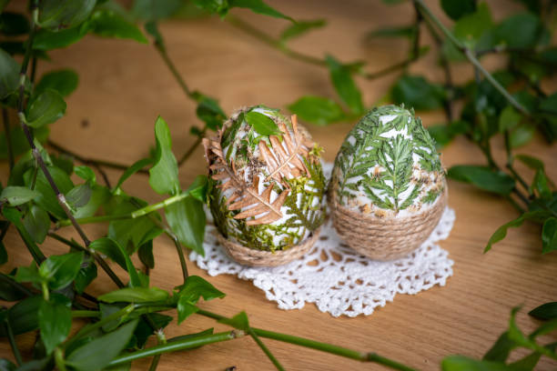 Forest themed Easter eggs decorated with natural leafs - holiday table decoration during celebration
