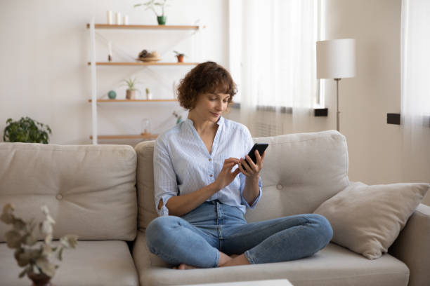 istock Caucasian woman sit on couch using smartphone 1272962331