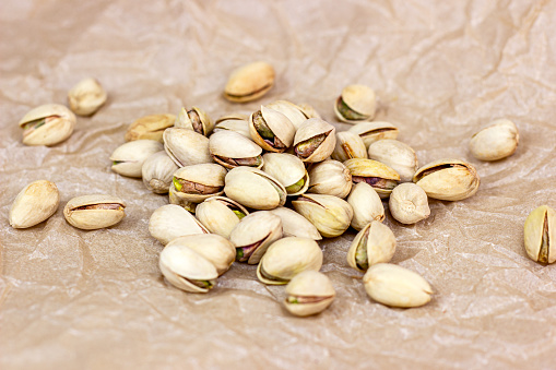 Roasted salted pistachio nuts in nutshell on light background.