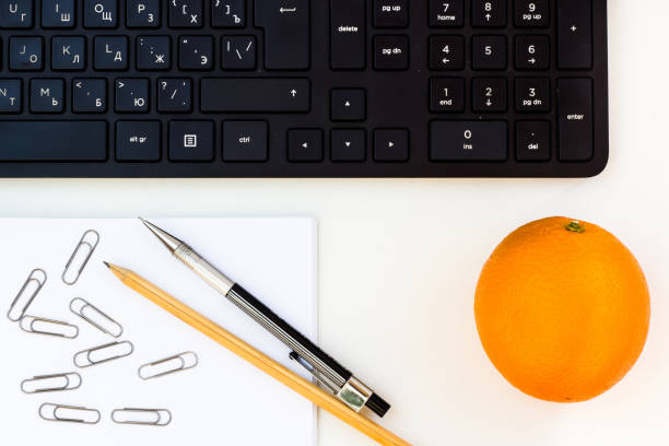 istock Keyboard, pencil, notebook, paper clips, orange. 1272964188