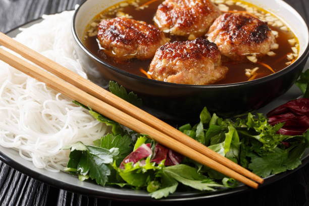 Bun cha is a Vietnamese dish of grilled pork, noodle and herb closeup in the plate. Horizontal