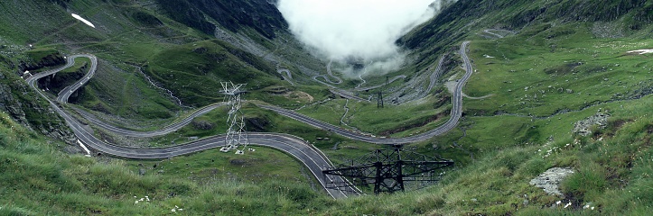 Aerial grayscale of the majestic fog-covered mountains and winding Transfagarasan road