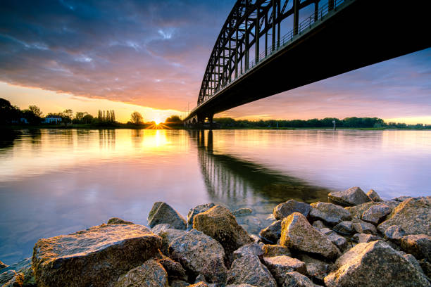 istock Striking arch bridge spans the river during the sunrise 1272966416