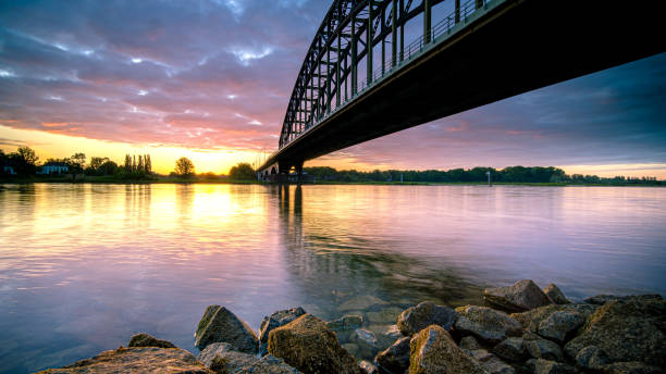 istock Striking arch bridge spans the river during the sunrise 1272966443
