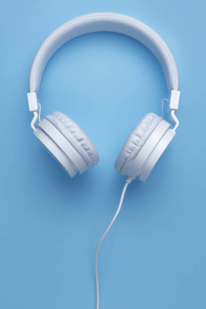 istock Close-up vertical image of white headphone on blue background. Music concept. 1272967255