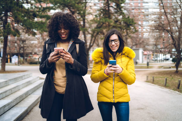 istock Checking social media while walking with friend 1272968436