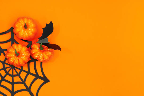 istock Halloween flat lay with pumpkins, spiders and bat on the orange background 1272969781