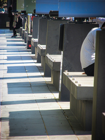 Southbank, AU - 25 Sept 2018: Shadows of concrete benches along the Southbank Promenade. This riverside location has a great atmosphere amidst buskers, shops, river cruises, arts and markets.