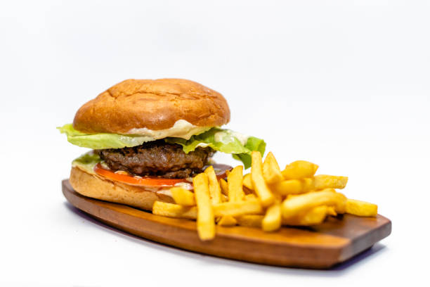 классический говяжий гамбургер с картофелем фри рядом - barbecue beef close up multi colored стоковые фото и изображения