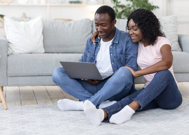 istock African american lovers sittng on floor at home, using laptop 1272971857