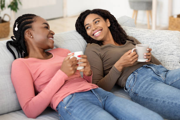 istock Relaxed girlfriends drinking coffee together at home 1272971891