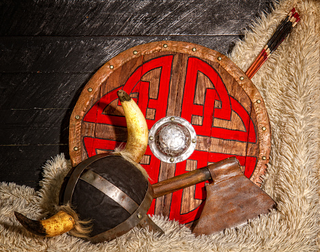 steel ax horned helmet and wooden viking shield with pattern