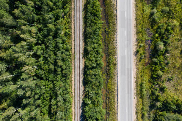 istock Asphalt road and train railway at the forest. Top view 1272973538