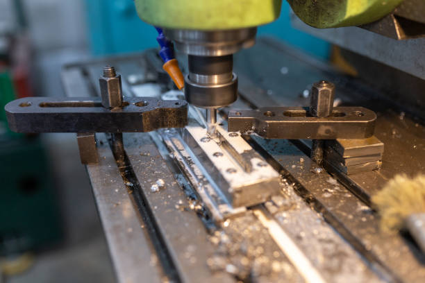 istock Execution of the work process on an industrial milling machine. The metal part is clamped in the collet. The cutter makes a longitudinal groove. Coolant is supplied. Metal shavings fly to the sides. 1272974181