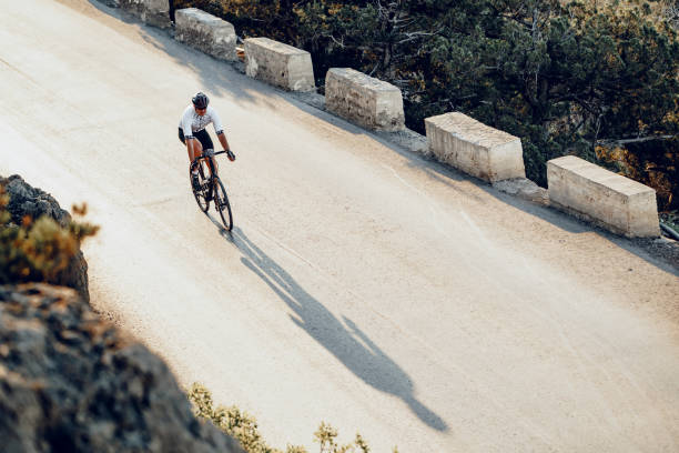 istock Professional cyclist on a mountain road at sunrise 1272975477