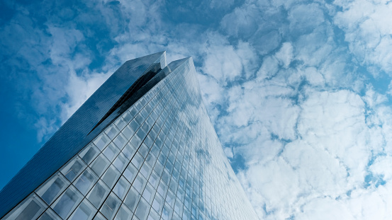 A designed, twisted high rise building against the backdrop of a winter, light cloudy sky, Tel Aviv, Israel.