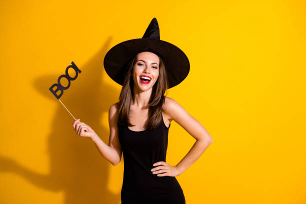 portrait of her she nice attractive pretty charming cheerful cheery lady wizard holding in hand glasses boo having fun festival isolated bright vivid shine vibrant yellow color background - witch beauty beautiful women imagens e fotografias de stock