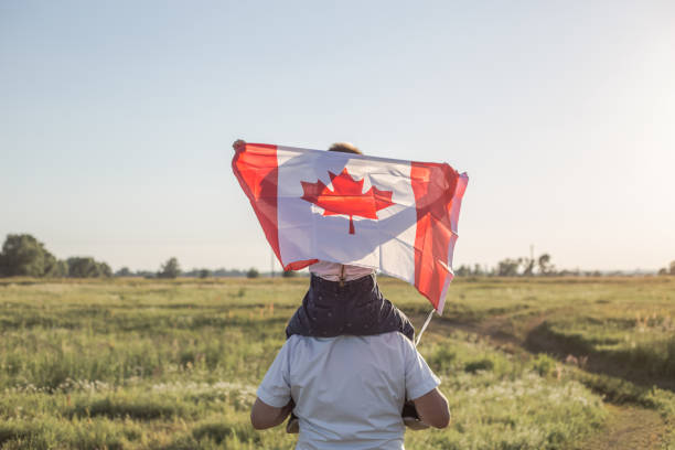 attractive old senior  man and grahdson holding canadian flag. national holiday. grandpa retiree. retirement parent - canadian flag canada flag canada day imagens e fotografias de stock