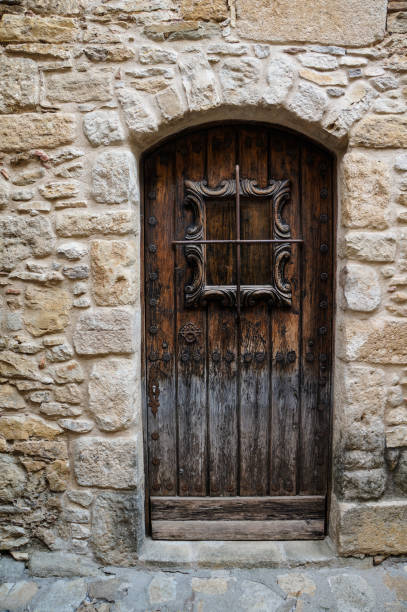 istock Old wooden door in stone facade 1272980193