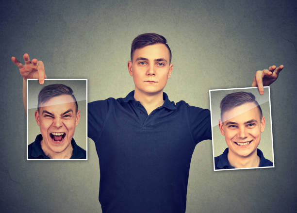 istock Serious man holding two different face emotion masks of himself 1272983750