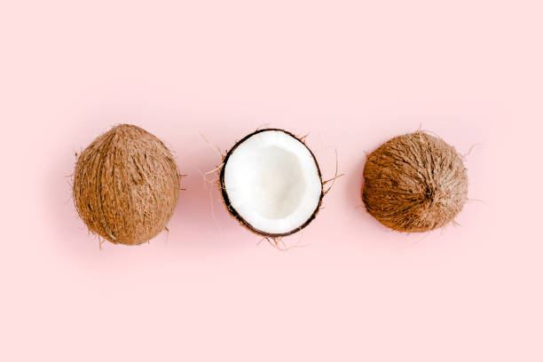 istock Pattern with coconuts and tropical palm leaves on pink background. Tropical abstract background. Flat lay, top view 1272984011