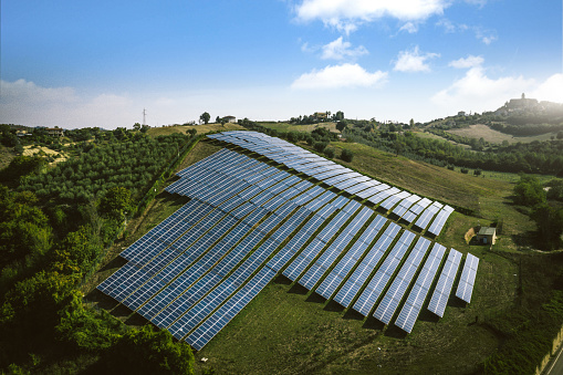New solar panels on a green hill in Italian countryside from an aerial point of view.