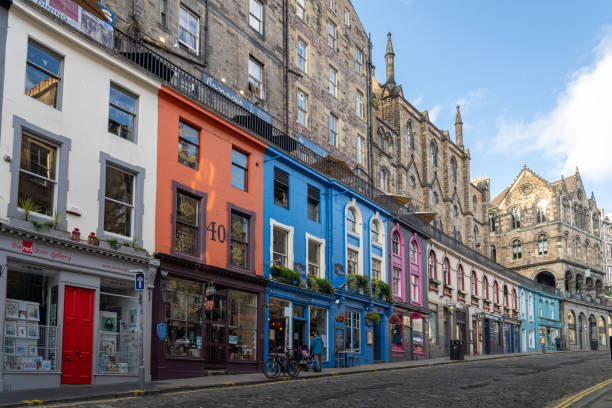 View of Victoria street in Edinburgh, Scotland. Steep picturesque street in the Old Town with small independent shops Edinburgh, Scotland, UK - August 24: View of Victoria street. Steep picturesque street winding in the Old Town with tall historical buildings and small independent shops store wall surrounding wall facade stock pictures, royalty-free photos & images