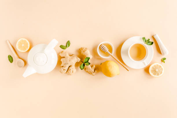 istock Herbal tea with mint, ginger, lemon, honey and other herbs on yellow background. Flat lay, top view 1272986374